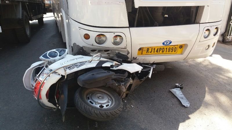 बाल बाल बची जान, बस के नीचे आया स्कूटर